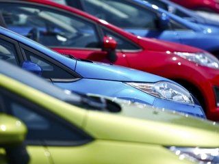 Una fila di auto di colori diversi sono parcheggiate una accanto all'altra.