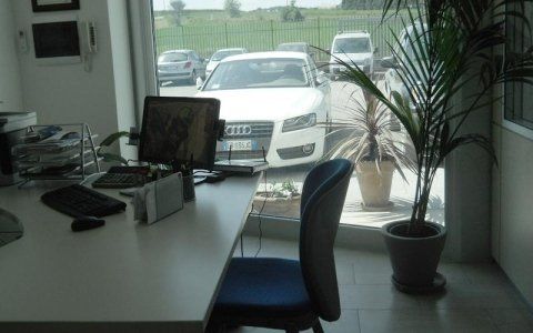 Un'auto bianca è parcheggiata davanti alla finestra di un ufficio