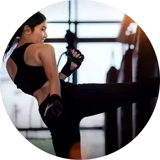girl kicking a black back in a kickboxing studio