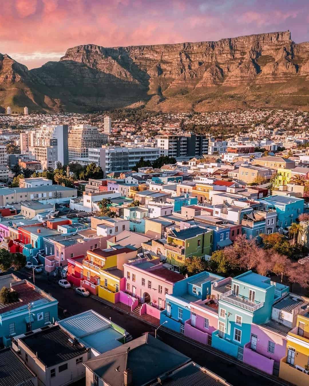Colorful houses in Bo-Kaap neighborhood, Cape Town, South Africa, with Table Mountain in the background.