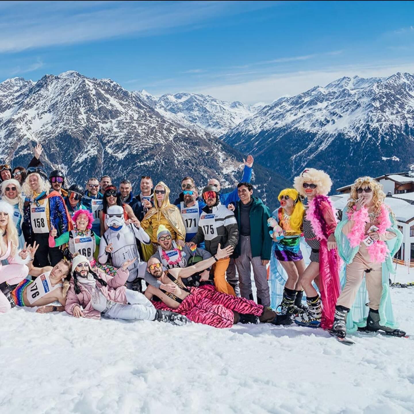 Group of costumed people pose in the snow with mountain backdrop. Sölden, Austria

