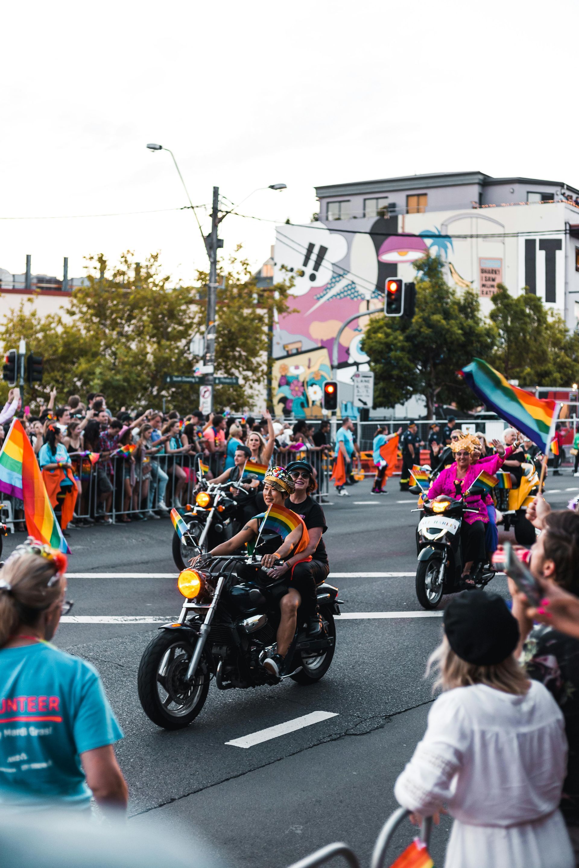 A group of people walks outdoors in a parade, carrying a colorful