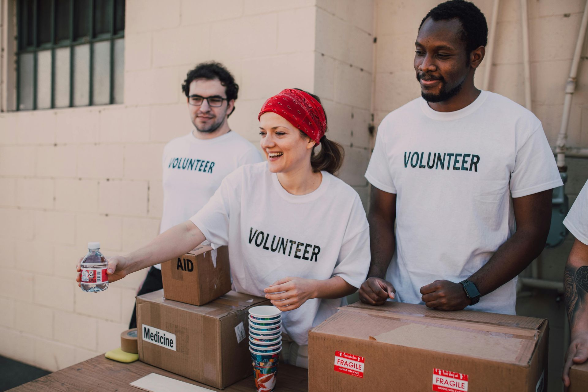 Three volunteers wearing white shirts with 