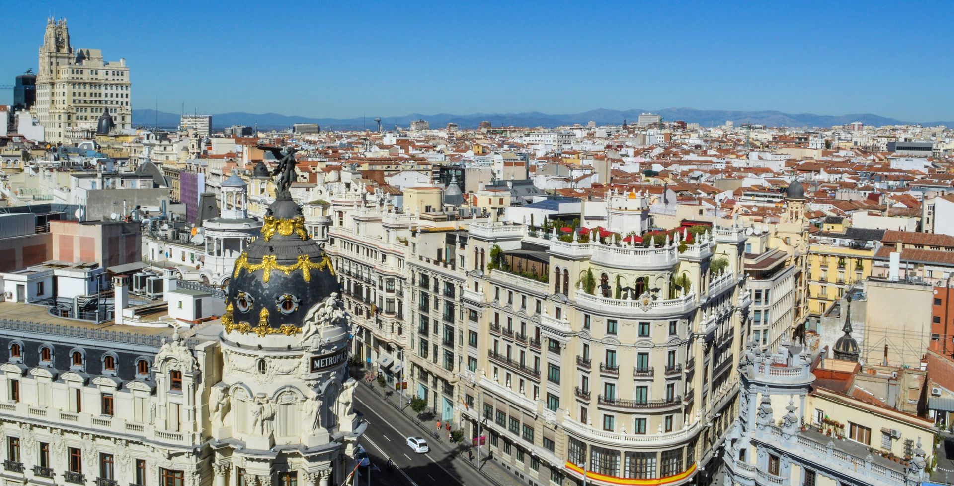 Panoramic cityscape of Barcelona with ornate buildings and the black-and-gold dome of a historic landmark