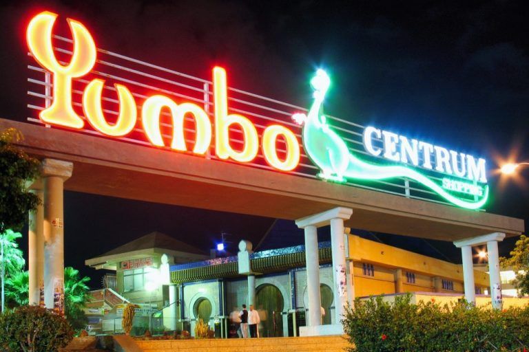 Neon sign for Yumbo Centrum shopping center, nighttime exterior view.