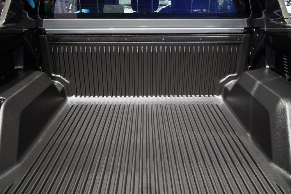 Black truck bed with ribbed floor and back, a protective liner.