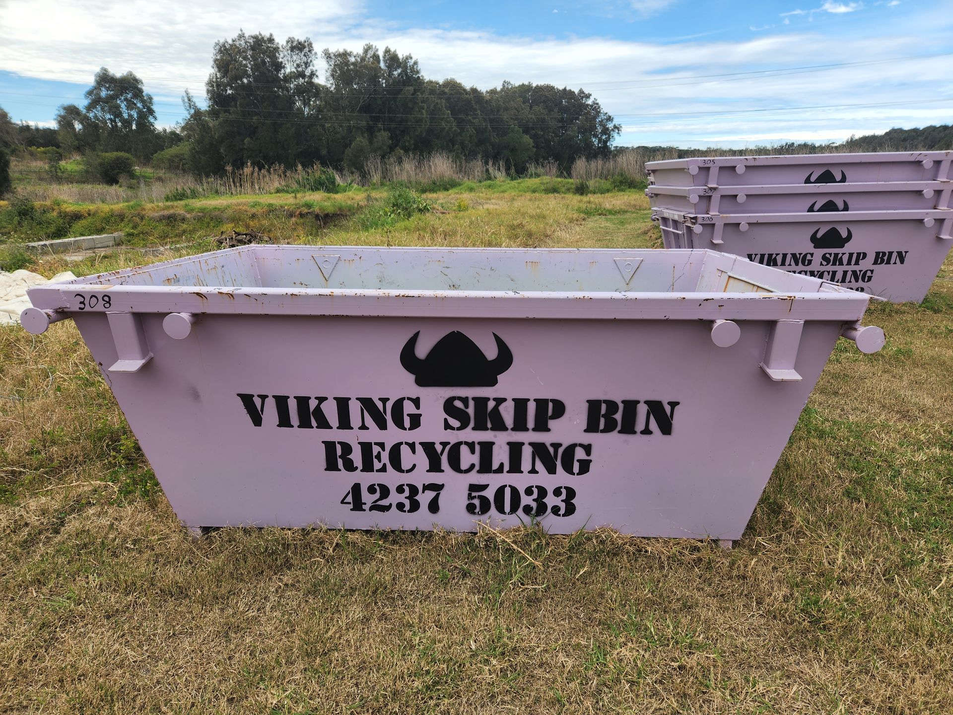 A Large purple dumpster is sitting in a field — Viking Skip Bin Recycling In Bomaderry, NSW