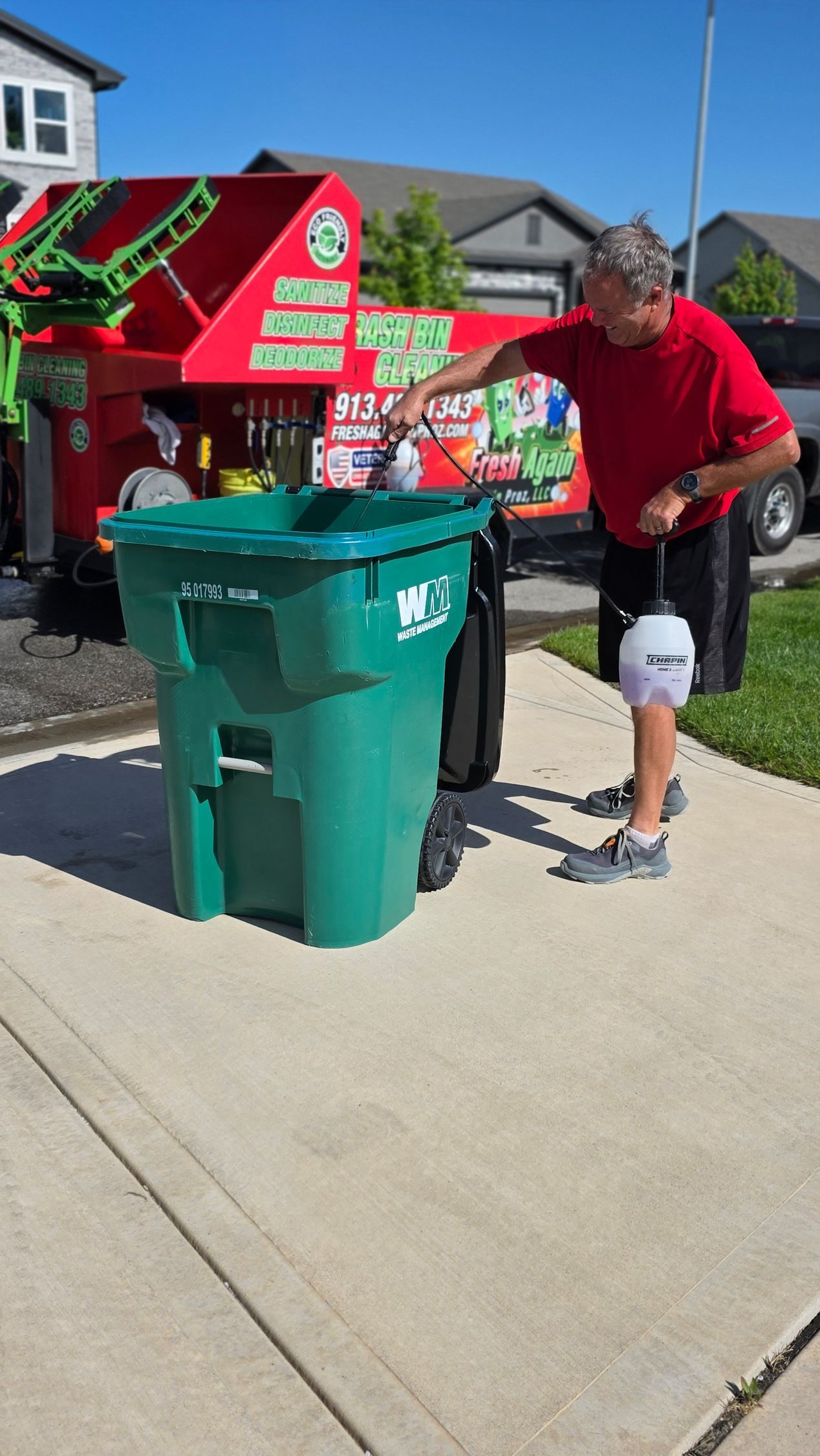 Phil applying biodegradable disinfectant to a clean bin