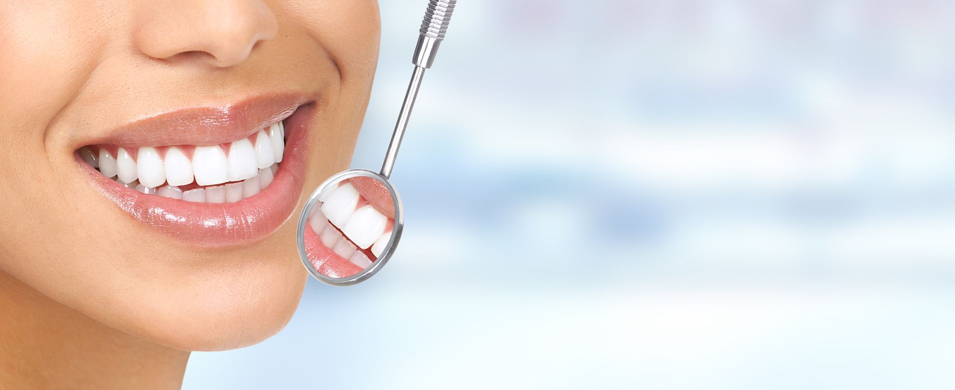 Close-up of a woman's bright white smile with a dental mirror reflecting her teeth