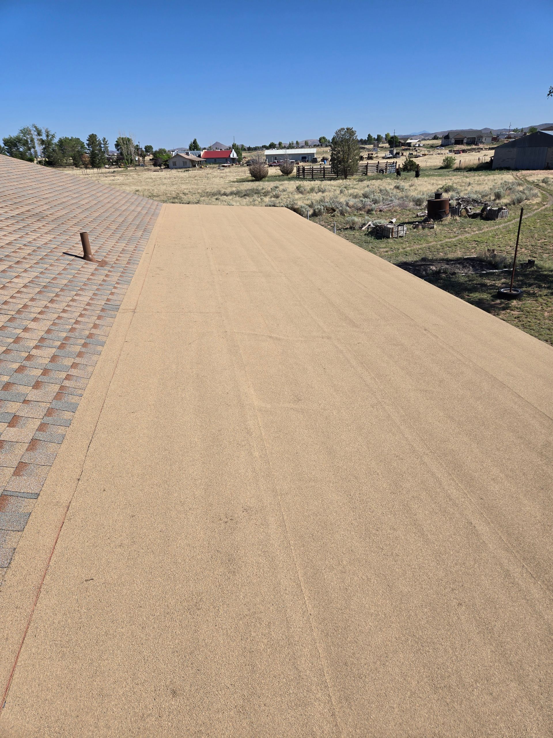 Curved tan walking path through a grassy neighborhood under a clear blue sky