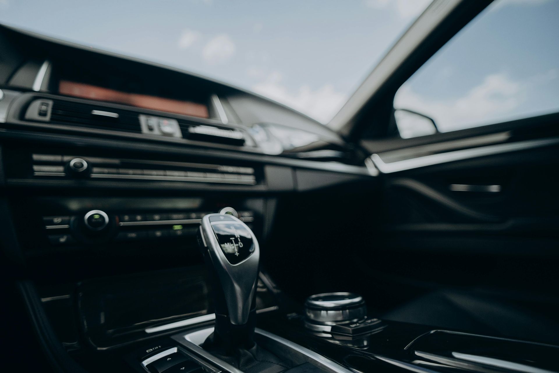 Car interior with center console, gear shift, and dashboard, viewed from the passenger side.