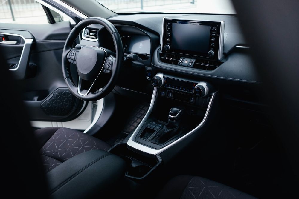 Modern car interior with steering wheel, dashboard display, and center console