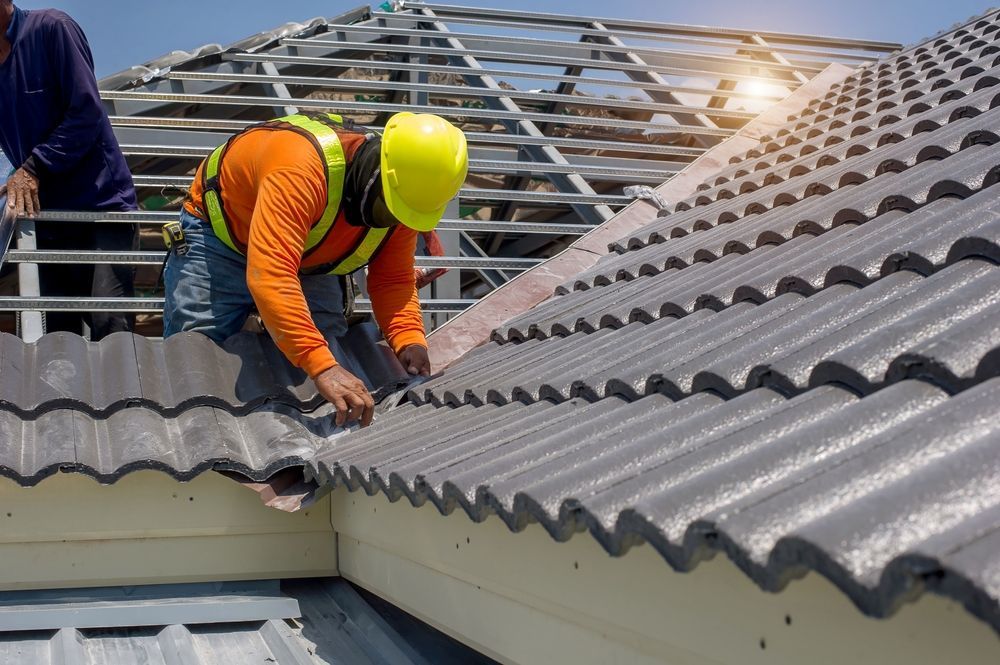 Roofer In Orange Shirt, Yellow Helmet, And Safety Harness — Coral Coast Roofing In Gordonvale, QLD