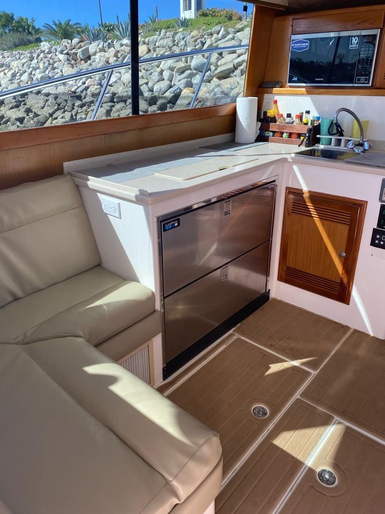 A kitchen on a boat with a couch and a sink.