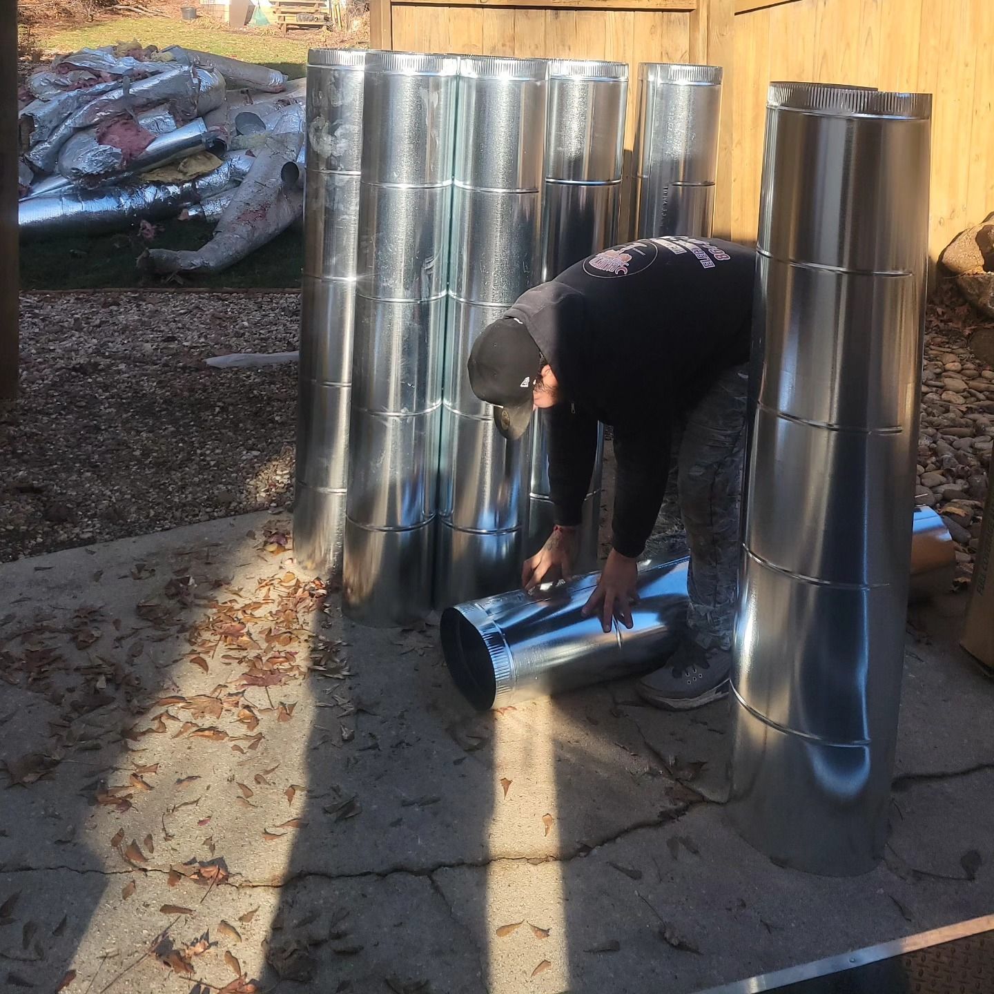 A man is working on a bunch of metal pipes