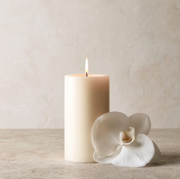 Memorial candle and white orchid arrangement for funeral services in Punta Gorda, FL.