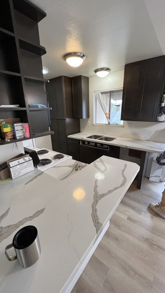 A kitchen with a coffee mug on the counter and a stove.