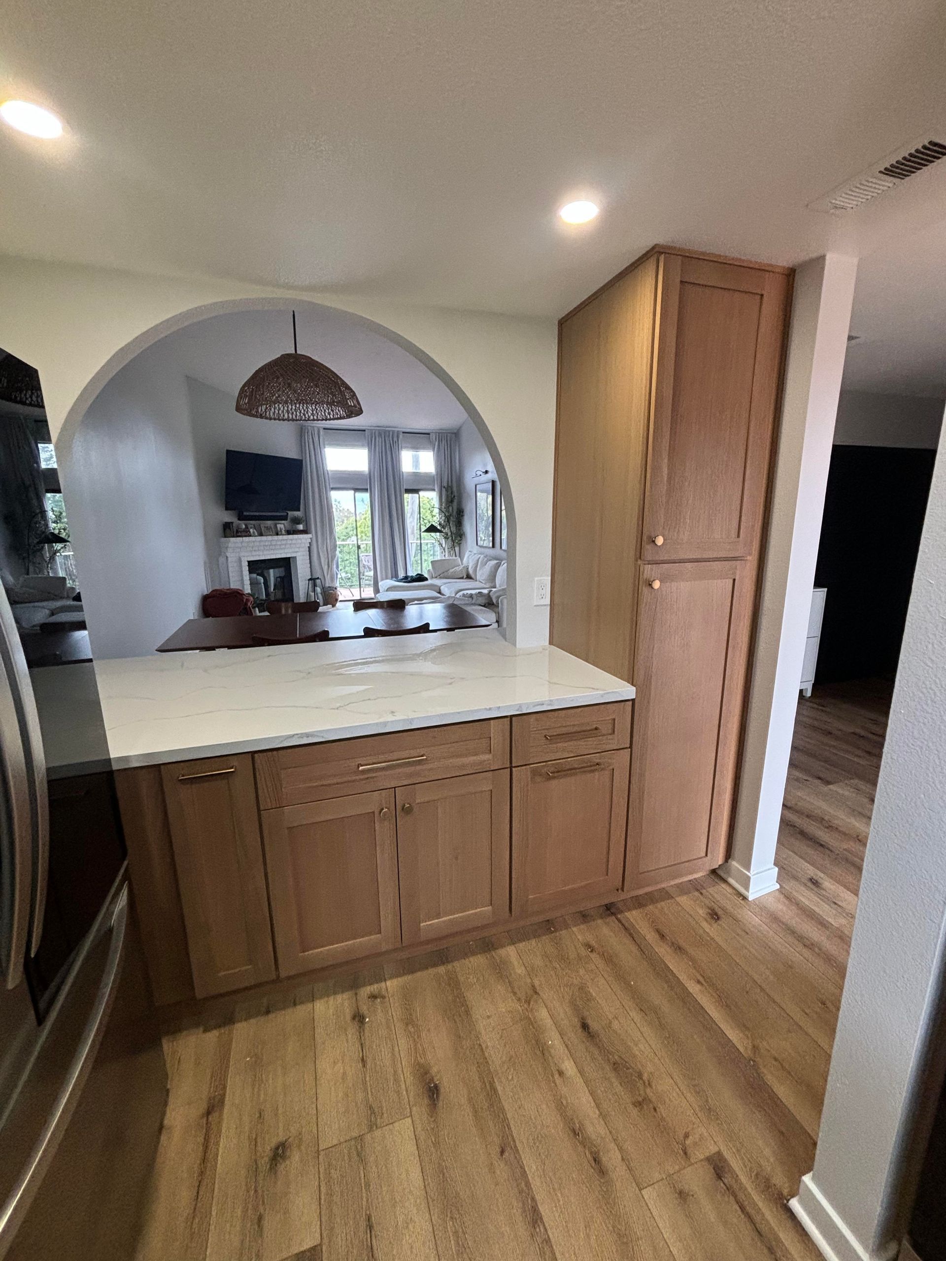 A kitchen with wooden cabinets and a stainless steel refrigerator.