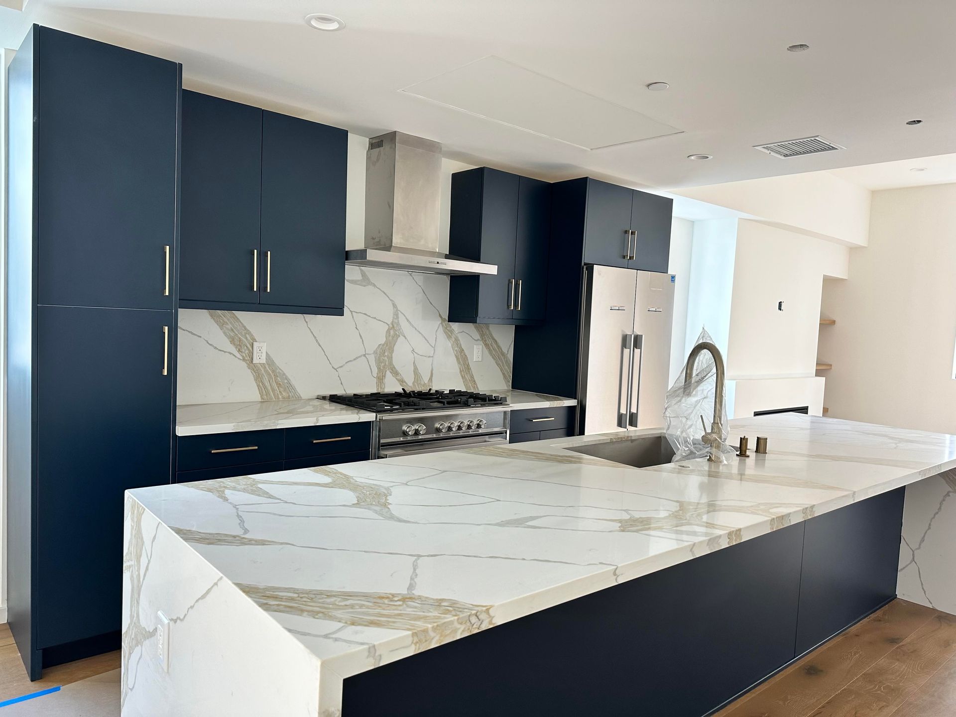 A kitchen with a large island and marble counter tops