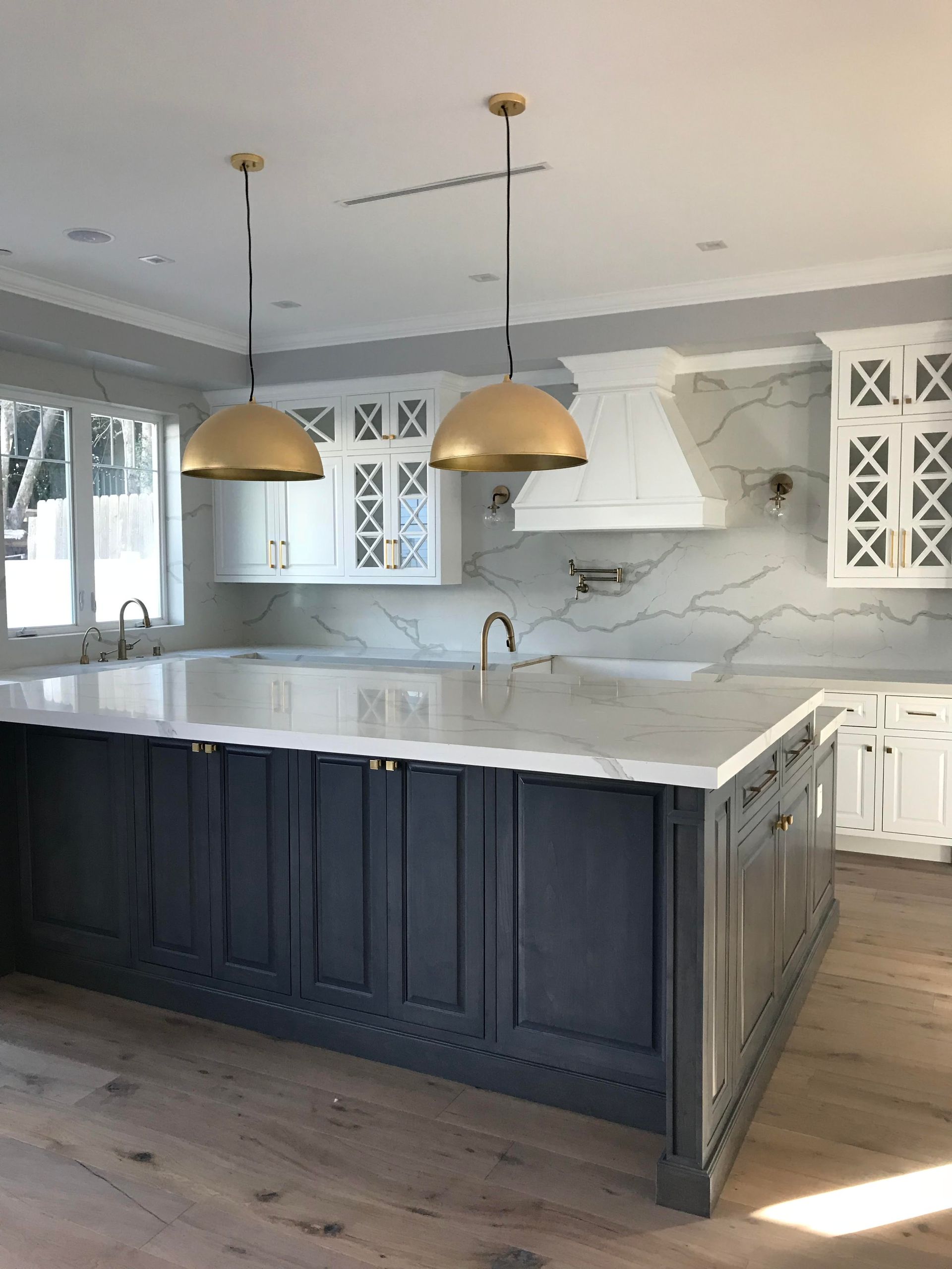 A kitchen with a large island and marble counter tops.