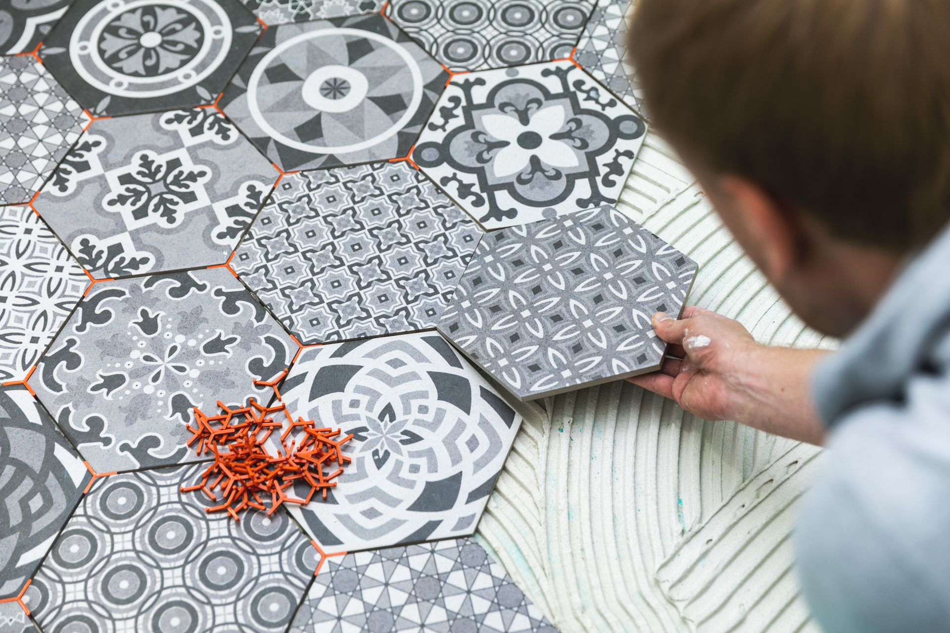 a man is laying tiles on a floor