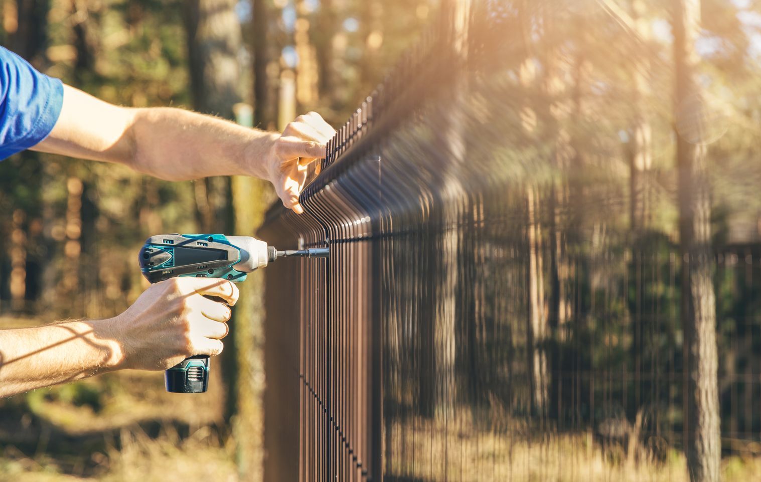 a man is installing a fence with a drill