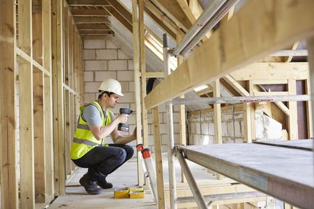 a construction worker is working on a wooden structure in a building under construction