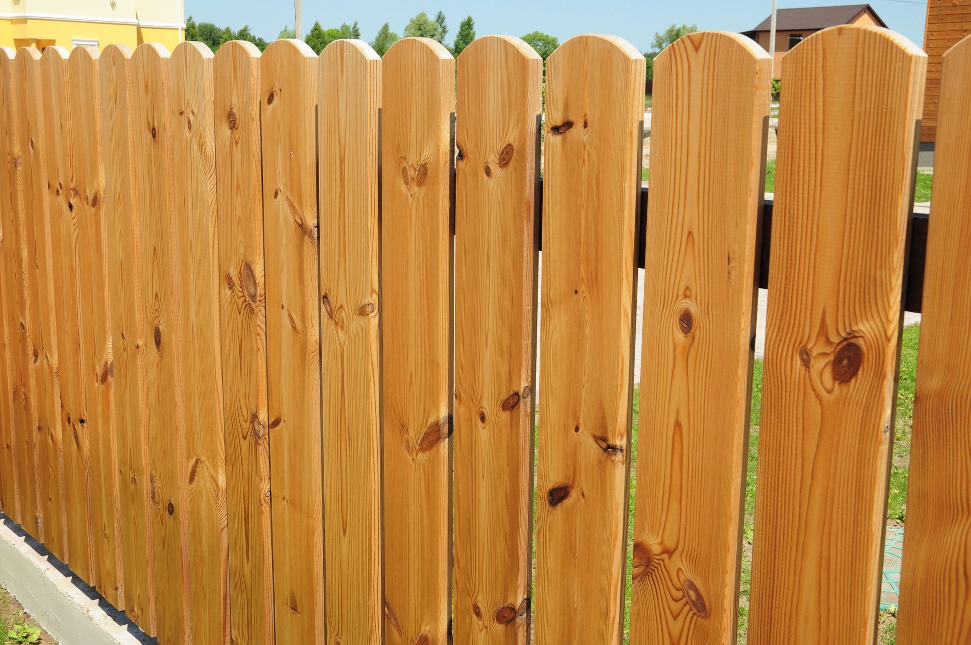 a wooden fence is sitting on top of a lush green field