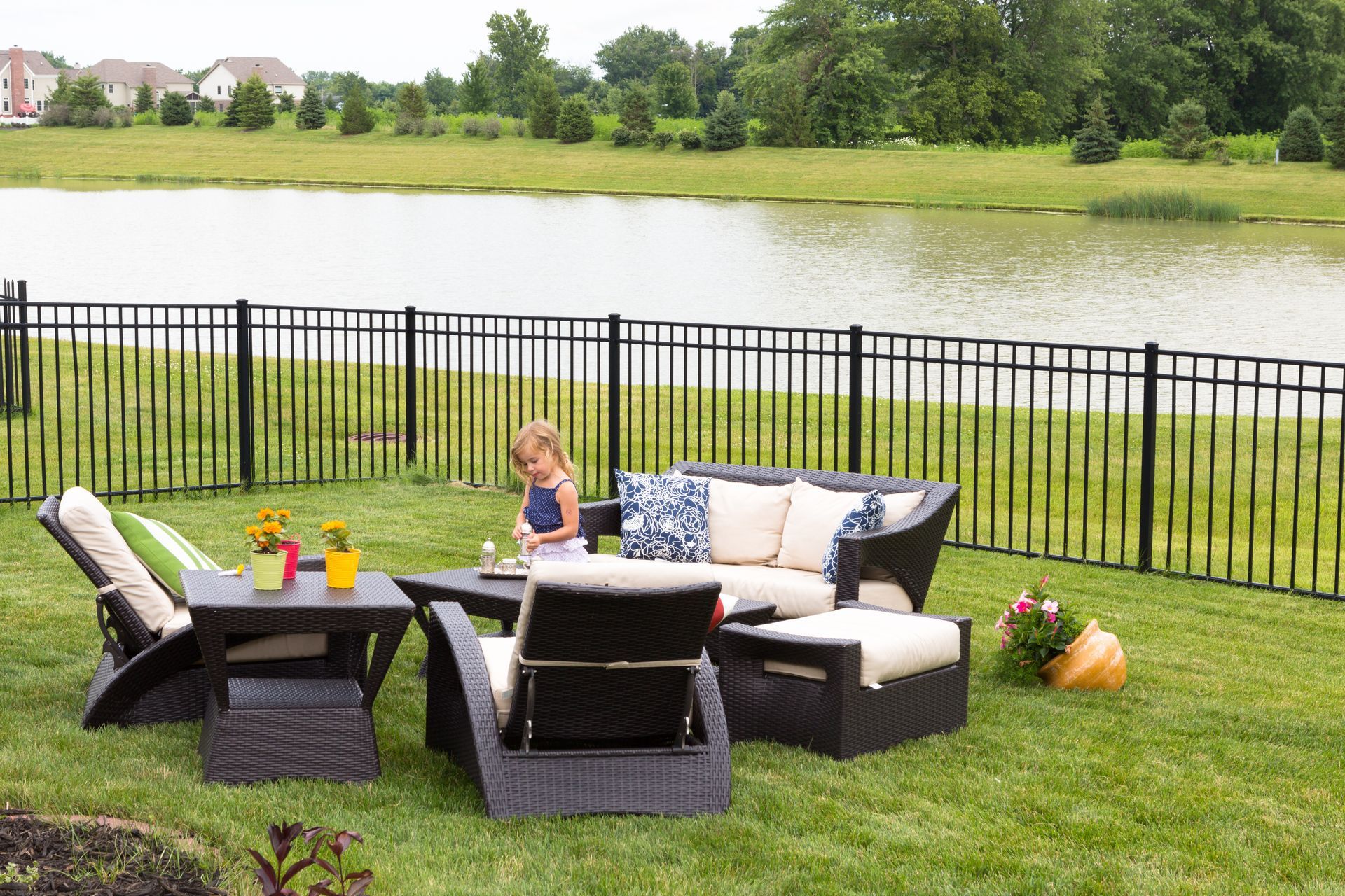 a child is sitting on a couch in a backyard next to a lake