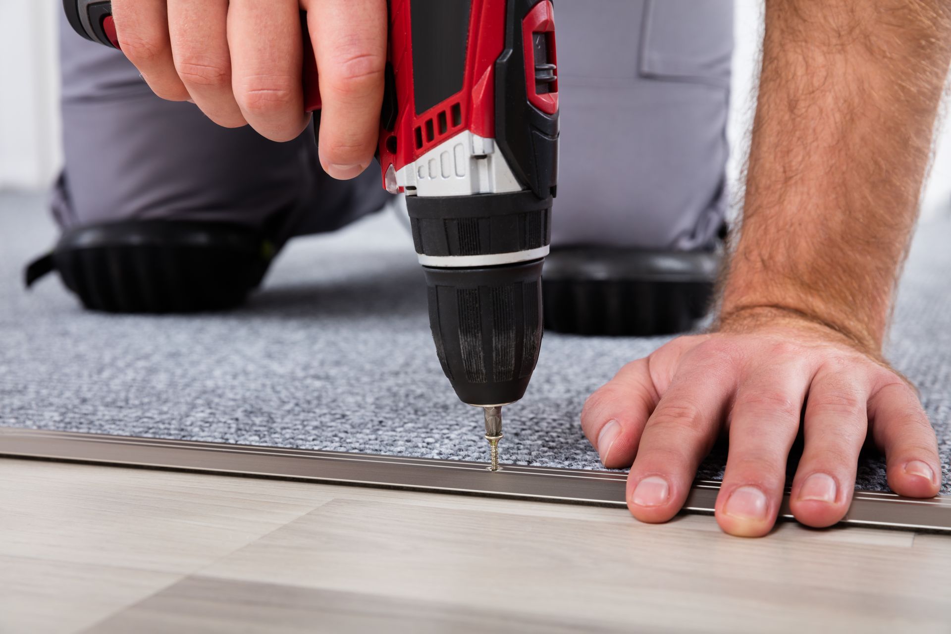 a man is using a drill to install a carpet on the floor