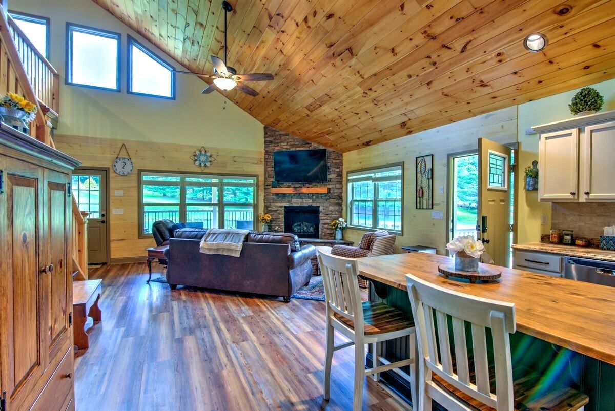 A living room with a vaulted ceiling and a fireplace.