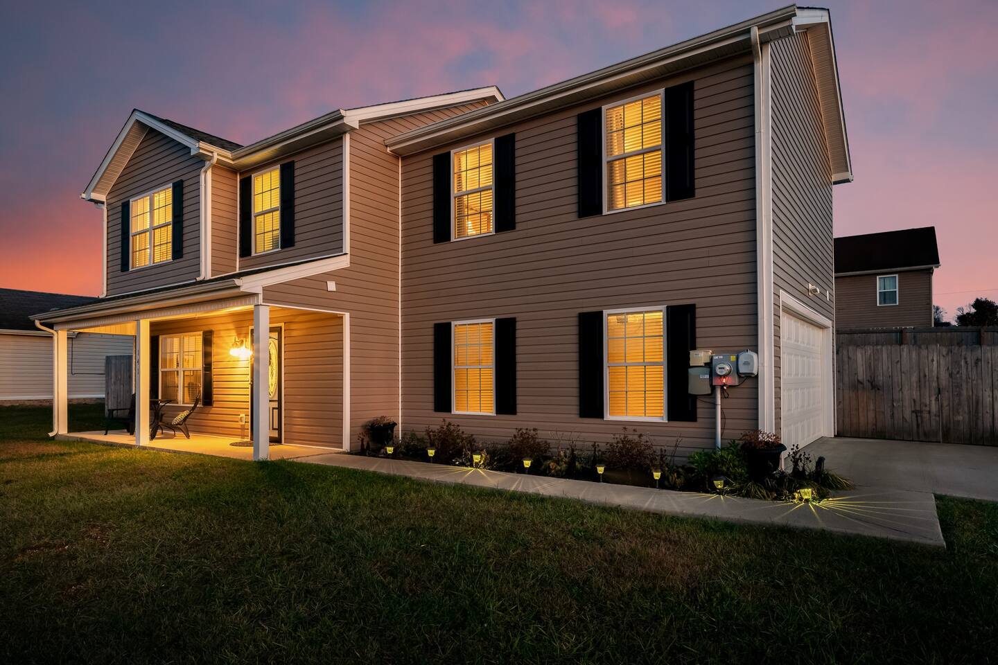 A house with a lot of windows and a porch at night