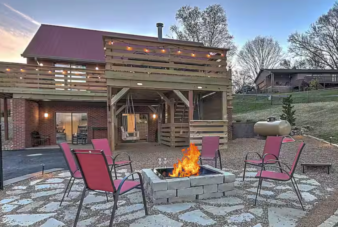 Gorgeous living room with brown leather couches, fireplace, and large TV in TN Livin's Johnson City Home