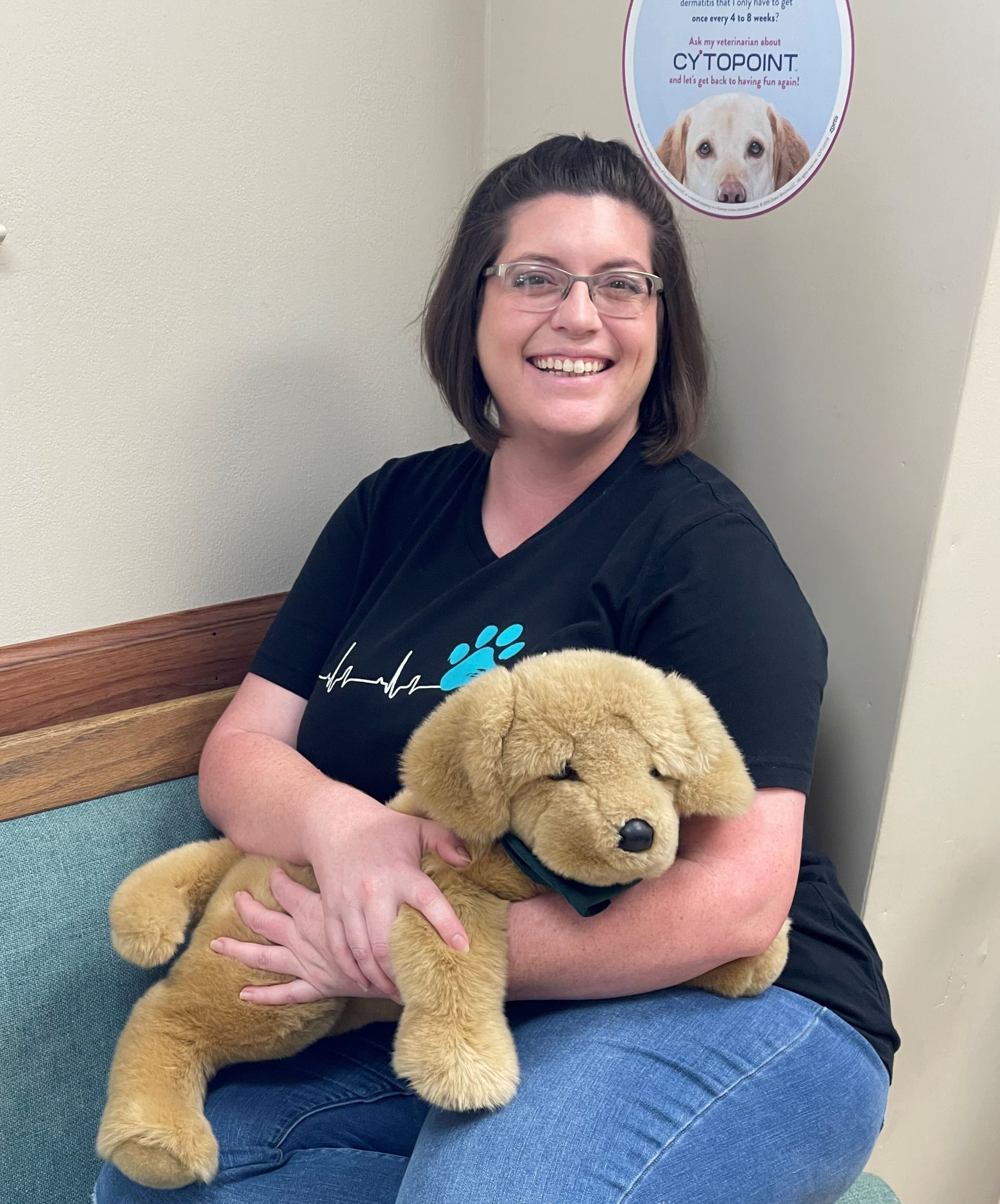 Vet tech & receptionist Krista holding dog plushie