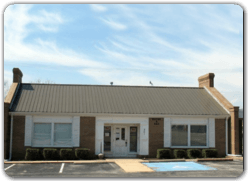 A small brick building with a metal roof