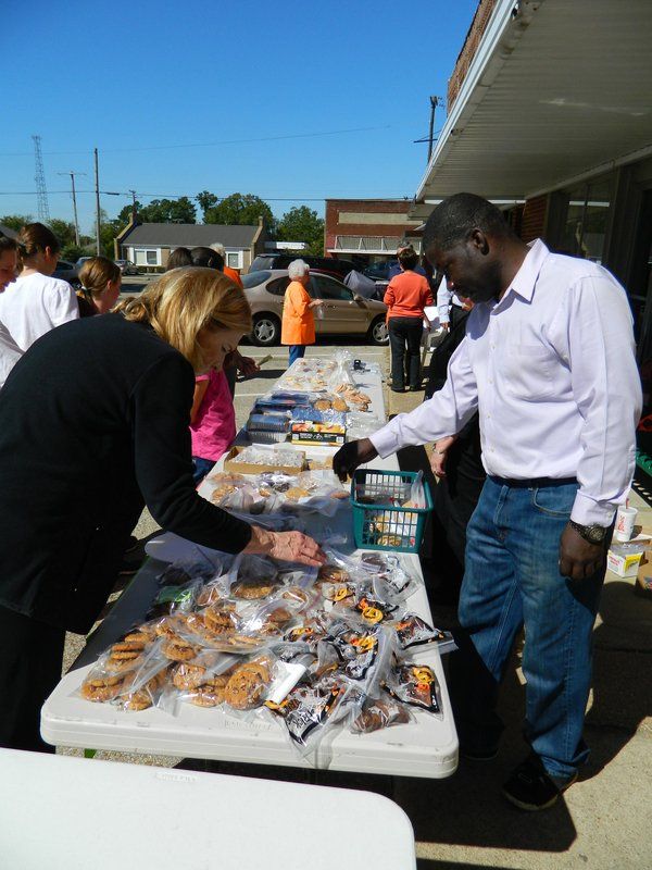 A man and a woman are looking at a table full of cookies