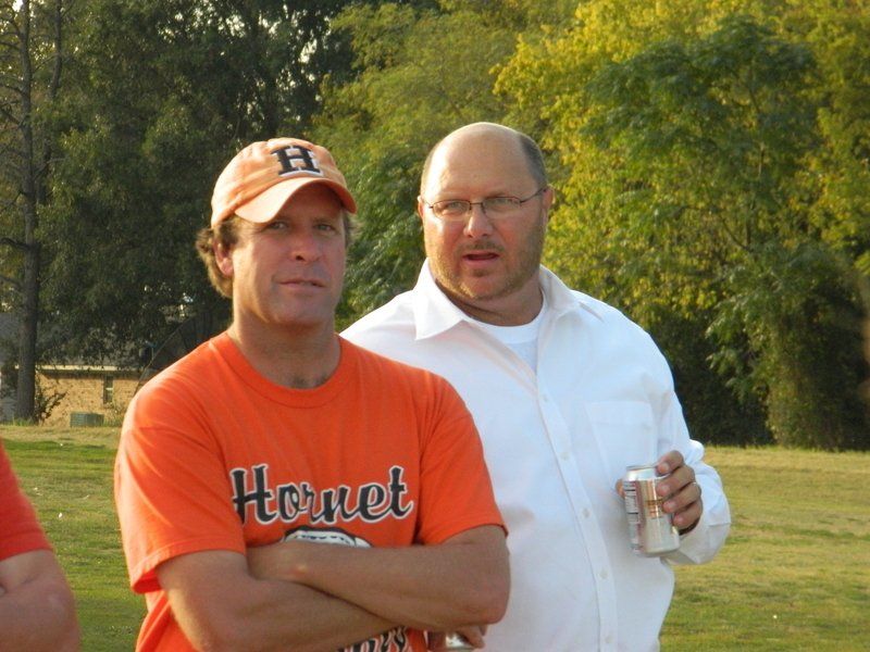 A man wearing an orange shirt with the word hornet on it