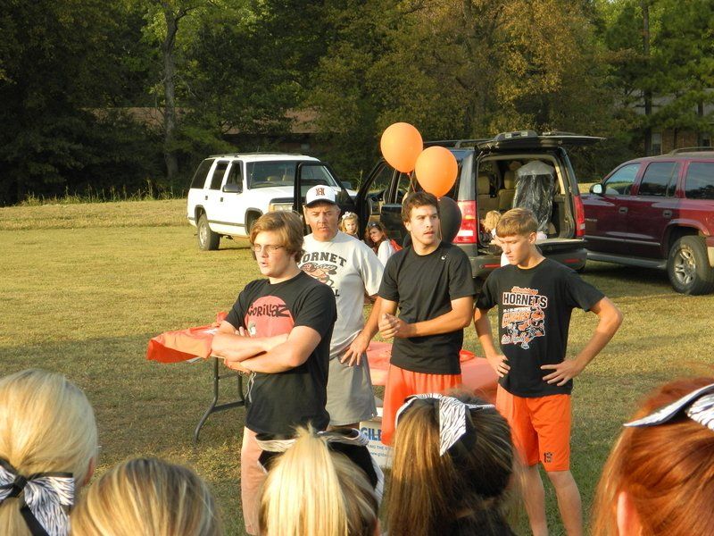A group of people standing in a field with balloons in the background