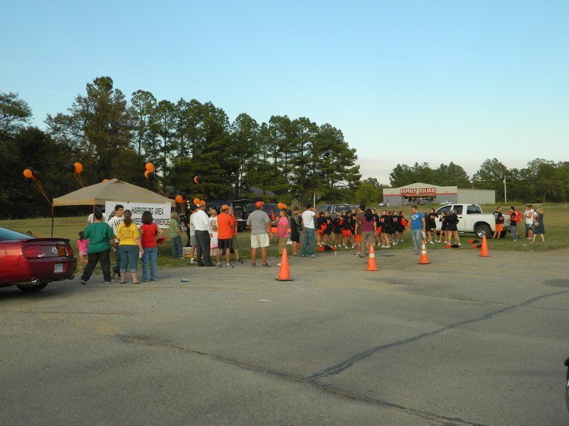 A group of people are gathered in a parking lot