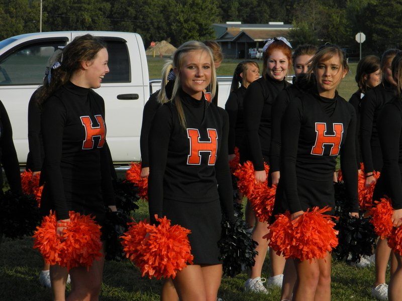 A group of cheerleaders with the letter h on their shirts