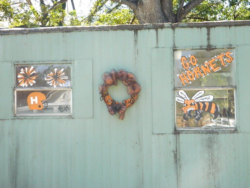 A green wall with a wreath and a sign that says go hornets
