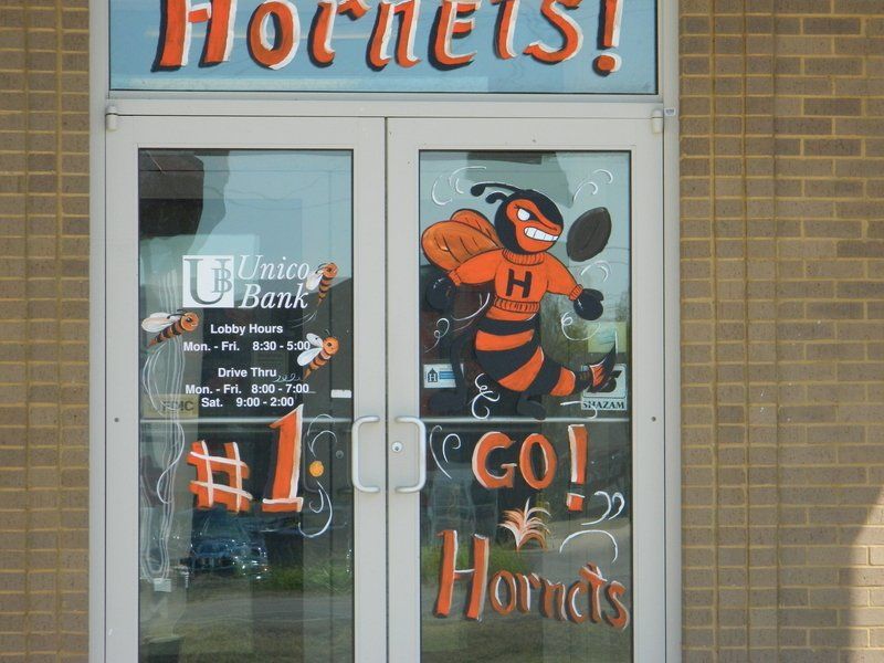 A hornets sign is painted on a glass door