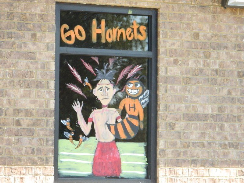 A brick building with a window that says go hornets