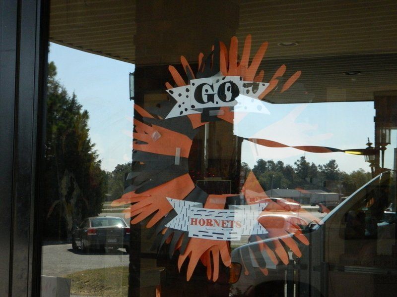 A sign on a window that says go hornets