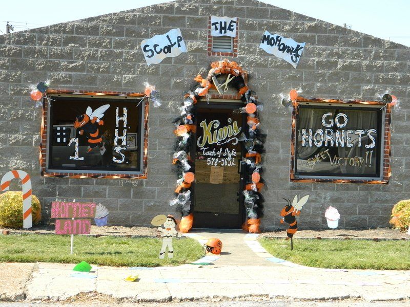 A brick building decorated for halloween with a sign that says go hornets