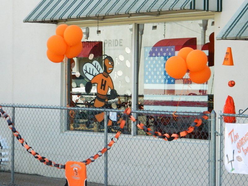 A store front with balloons and a sign that says pride