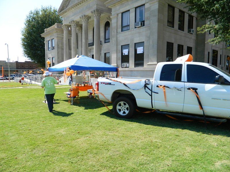 A white truck is parked in front of a large building