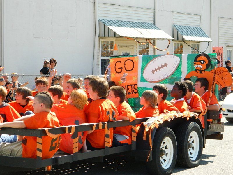 A group of children are riding on a trailer with a sign that says go jets