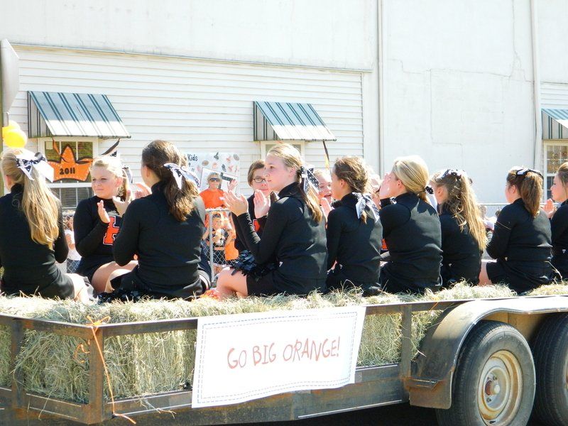 A group of people are sitting on a float that says go big orange