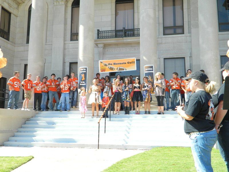 A group of people standing in front of a building with a sign that says 1